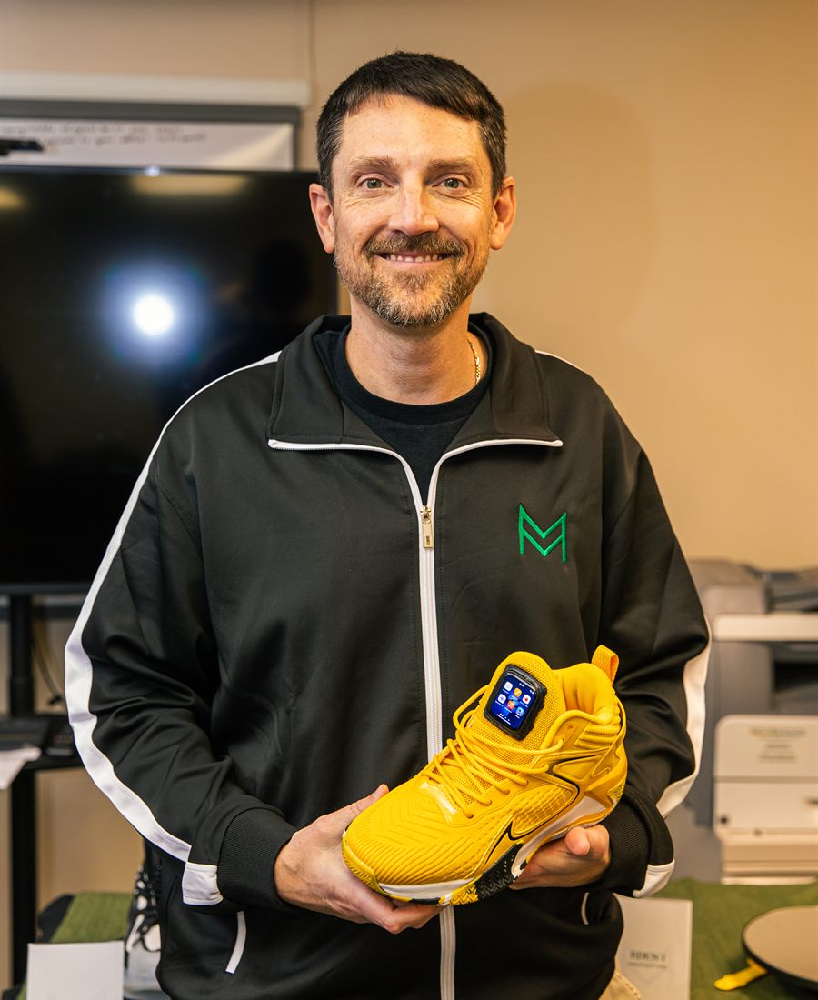 Dustin Donohew holding Omen footwear at a MiMiroir event